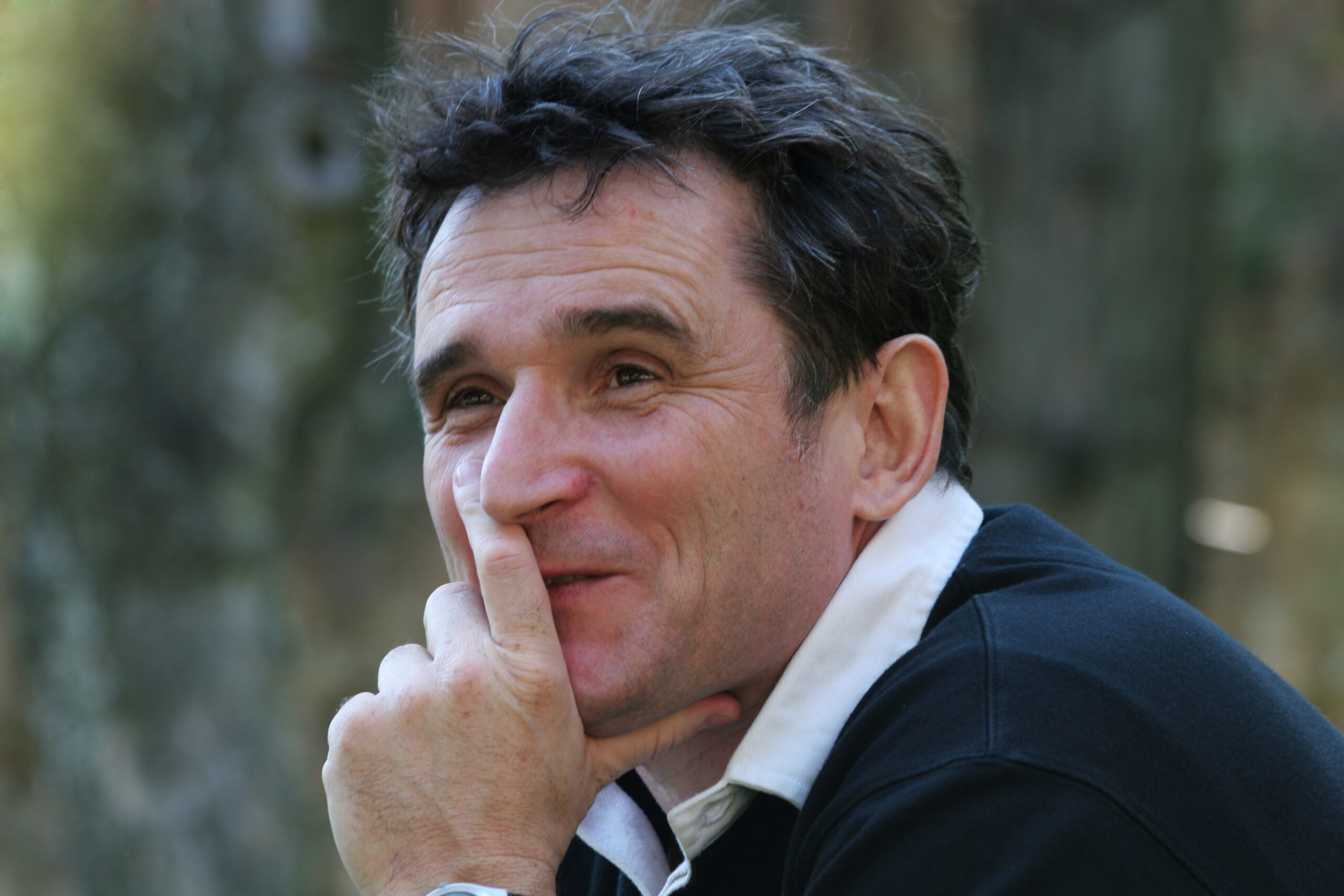 Auf diesem alten Foto blickt Walter Paulhart im Alter von etwa 40 Jahren in die Ferne. Sein Kinn ist auf seine Hand gestützt und er lächelt sanft.