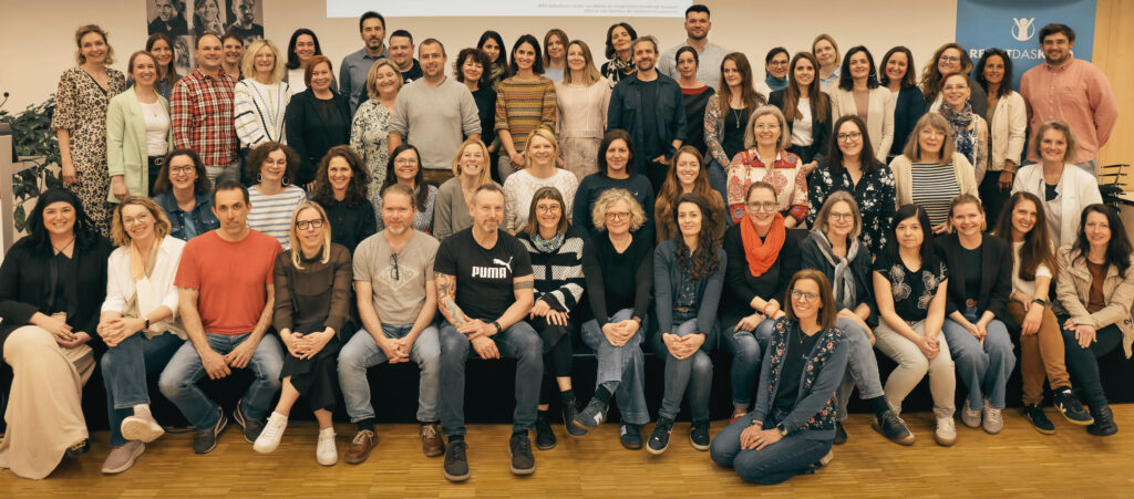 Das Team des Fachbereichs Berufliche Integration umfasst mehr als 70 Mitarbeiter:innen. 59 von ihnen posieren lächelnd für ein Gruppenfoto.