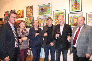 Walter Paulhart posiert auf einer Kunstveranstaltung des Vereins Kindergruppen Farbenfroh mit 3 weiteren Herren und zwei Damen für ein Foto.