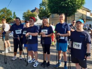 Die Nordic Walking Gruppe der Förderwerkstätte Großpetersdorf posiert vor dem Start des Charity Night Runs für ein gemeinsames Foto.