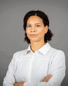 Katharina Musitz trägt ihr lockiges Haar leicht zusammengebunden. lächelnd blickt sie in die Kamera.