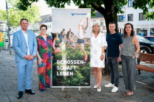 Die Verantwortlichen von Rettet das Kind Burgenland und der Volksbank posieren neben dem Volksbank-Banner für ein Foto.